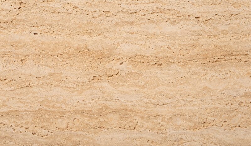 Prirodna tekstura travertino kamena sa karakterističnim porama, slojevitom strukturom i toplim bež tonovima